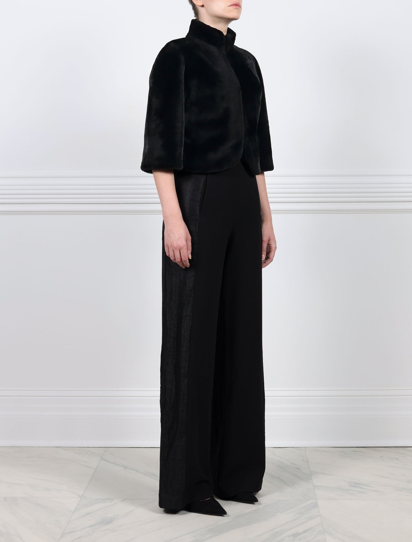 SIDE VIEW-BLACK SHEARLING JACKET-ROUNDED STAND COLLAR-THREE QUARTER LENGTH SLEEVES-HOOK AND EYE CLOSURES-19 INCH CENTER BACK LENGTH-BY POLOGEORGIS