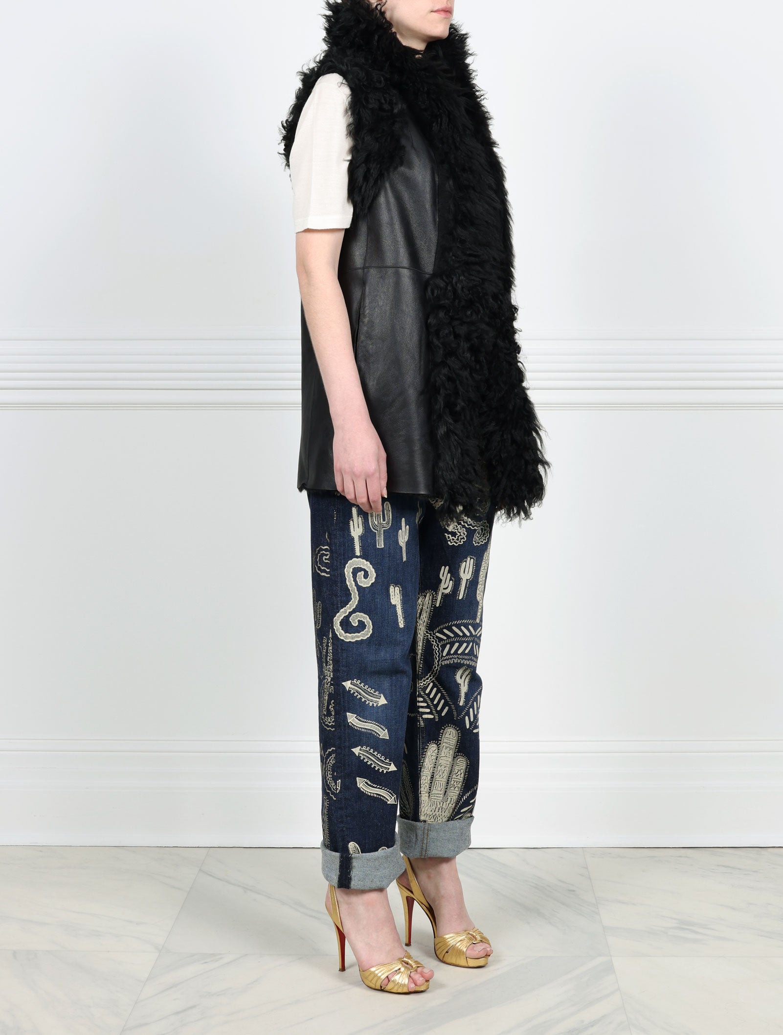 SIDE VIEW-KNITTED FLOWER PRINTED ON BLACK REVERSIBLE SHEARLING VEST DESIGNED BY ZANDRA RHODES FOR POLOGEORGIS-STAND COLLAR-SLIT POCKETS-SNAP CLOSURES-CURLY SHEARLING TRIM AT ARMHOLES AND TUXEDO-30 INCH CENTER BACK LENGTH