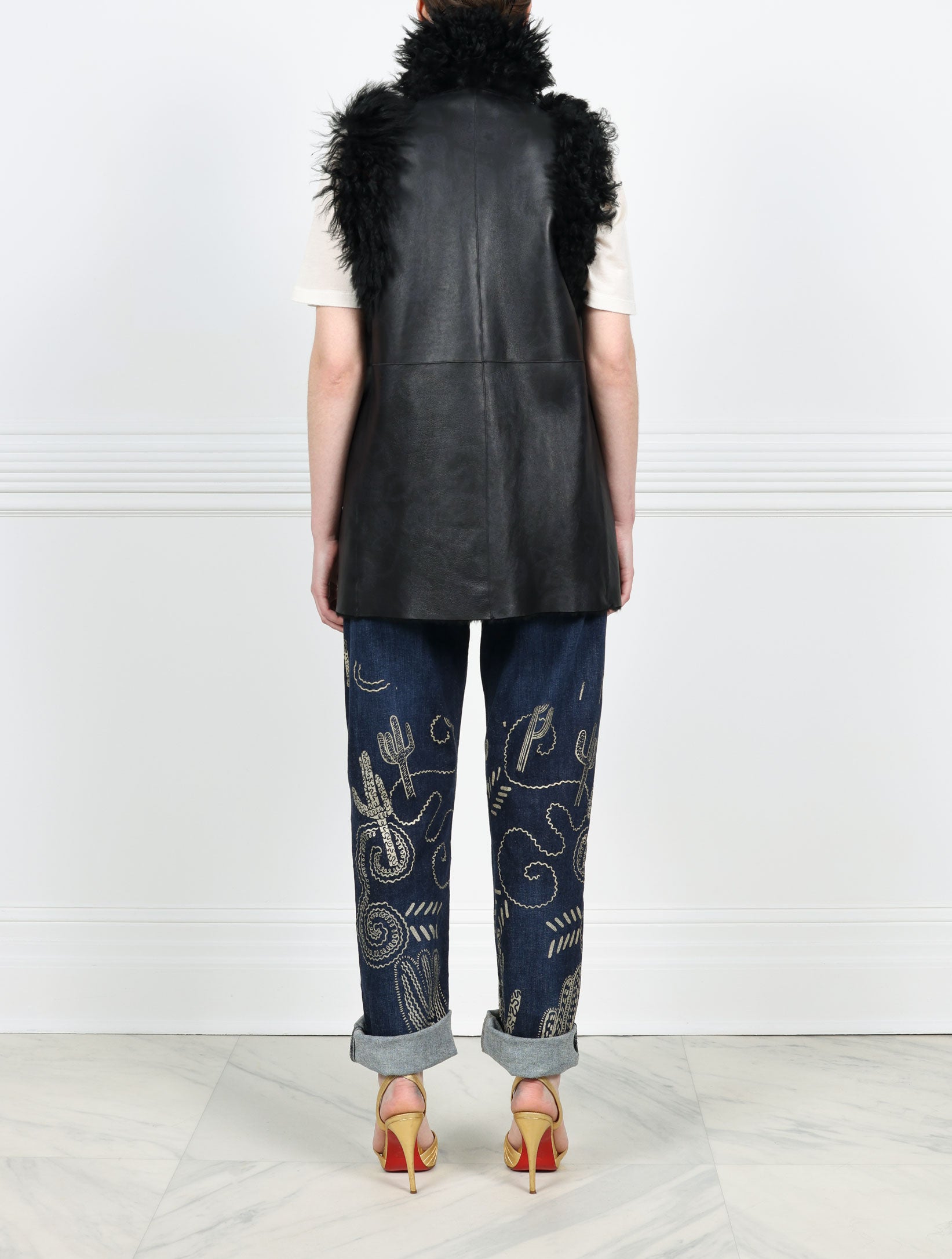 BACK VIEW-KNITTED FLOWER PRINTED ON BLACK REVERSIBLE SHEARLING VEST DESIGNED BY ZANDRA RHODES FOR POLOGEORGIS-STAND COLLAR-SLIT POCKETS-SNAP CLOSURES-CURLY SHEARLING TRIM AT ARMHOLES AND TUXEDO-30 INCH CENTER BACK LENGTH