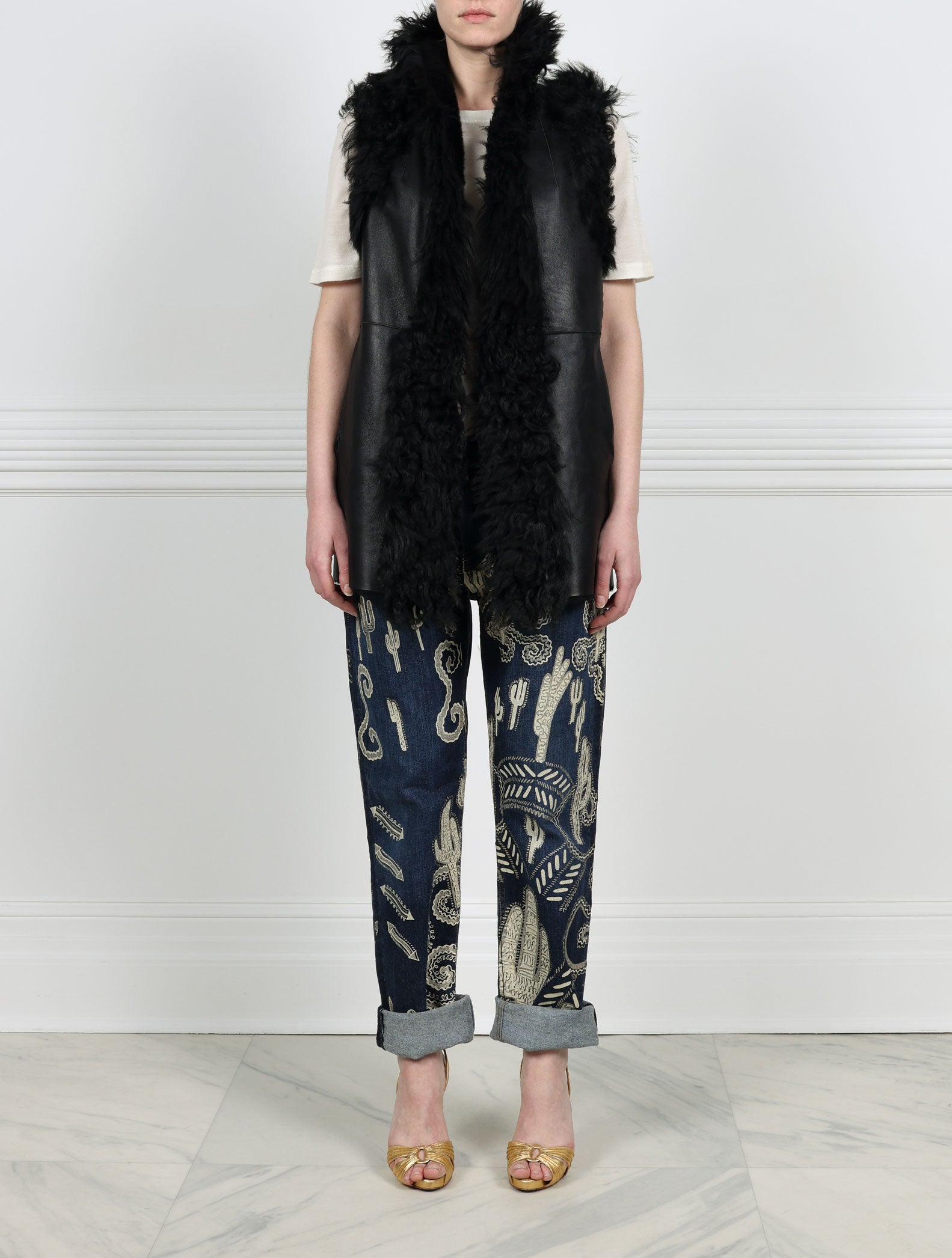 FRONT VIEW-KNITTED FLOWER PRINTED ON BLACK REVERSIBLE SHEARLING VEST DESIGNED BY ZANDRA RHODES FOR POLOGEORGIS-STAND COLLAR-SLIT POCKETS-SNAP CLOSURES-CURLY SHEARLING TRIM AT ARMHOLES AND TUXEDO-30 INCH CENTER BACK LENGTH