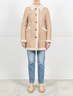 FRONT VIEW-TAN SHEARLING COAT WITH FUR OUT TRIM-FUR SHIRT COLLAR-STRAIGHT FULL LENGTH FUR TRIMMED SLEEVES-HORIZONTAL FUR TRIMMED PATCH POCKETS-BUTTON CLOSURES-FUR TRIMMED TUXEDO AND HEM-32 INCH CENTER BACK LENGTH-BY POLOGEORGIS