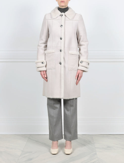 FRONT VIEW-WHITE SHEARLING BALMACAAN COAT-FUR SHIRT COLLAR-STRAIGHT FULL LENGTH SLEEVES WITH BUTTON TABS-FUR TRIMMED PATCH POCKETS, TUXEDO AND SLEEVE ENDS-BUTTON CLOSURES-38 INCH CENTER BACK LENGTH-BY POLOGEORGIS